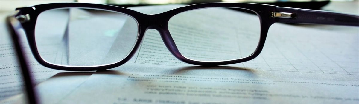 Black frame glasses on top of paper contract